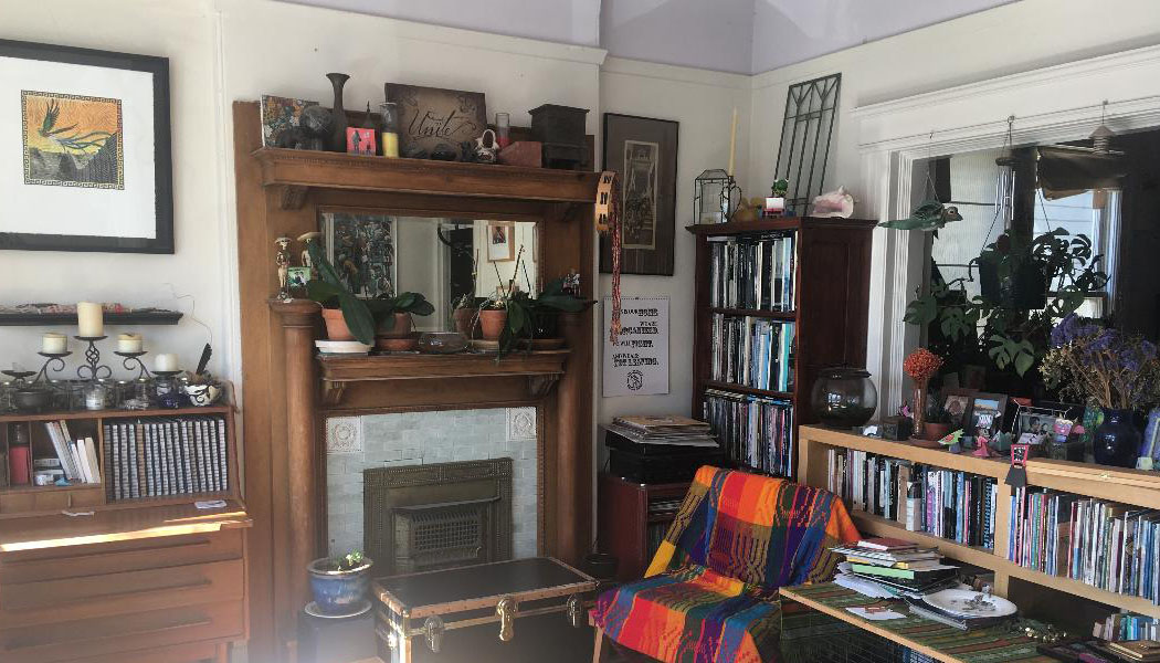 Photograph of living room with home altar, art, and books